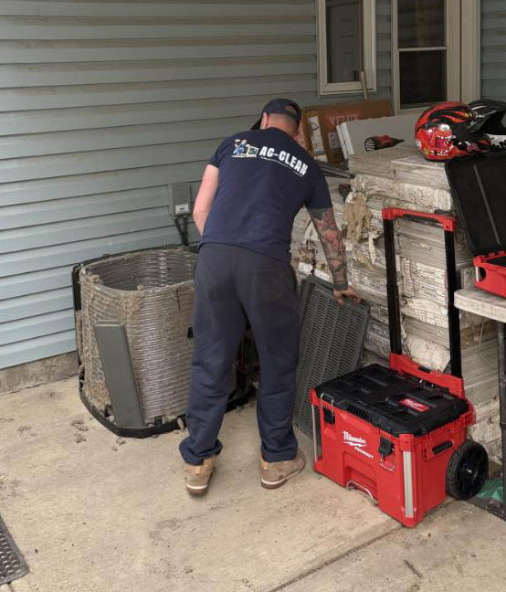 AC Clean technician working on an opened outdoor condenser coil